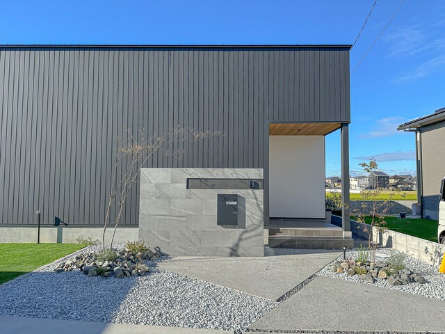 グレーのタイルがガルバの建物に映える門柱